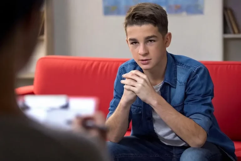 Psychotherapie & Psychomotorik Kinder und Jugendliche - Jugendlicher sitzt auf roter Couch